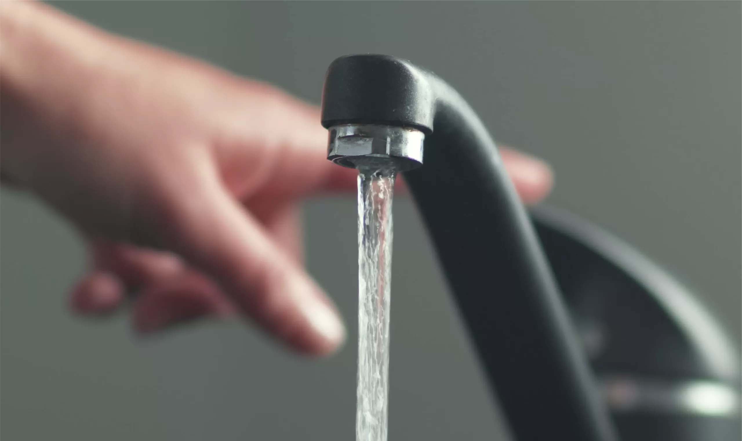 Steady stream of water coming out of a chrome faucet