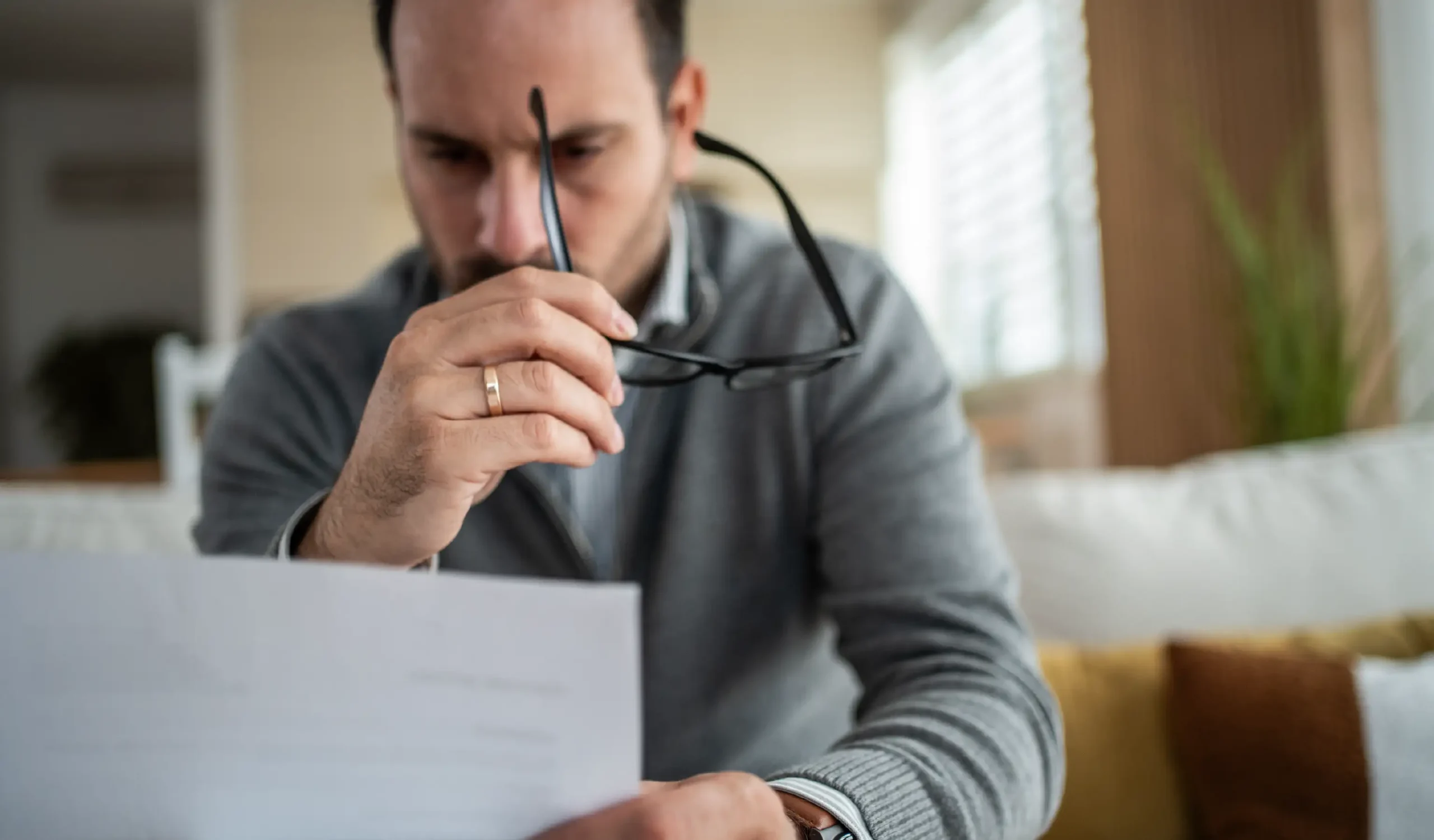 Man looking concerned as he's looking over insurance paperwork.