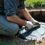 Man inspecting septic system, using a tool to open the tank.